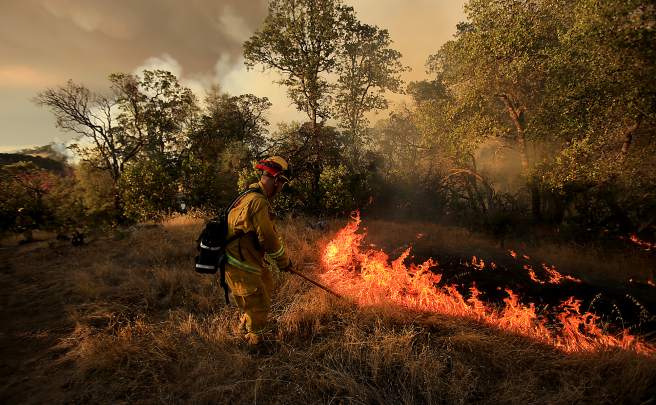 Smaller backfires were set by dragging burning brush to solidify containment lines on the Rocky Fire near Lower Lake  as they try to cut line around the perimeter of the fire, Wednesday July 29, 2015. (Kent Porter / Press Democrat) 2015