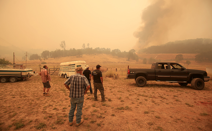 The Antonia family and friends watch as the Rocky Fire spots outside of containment lines, Thursday July 30, 2015 from their ranch off Morgan Valley Road. (Kent Porter / Press Democrat) 2015