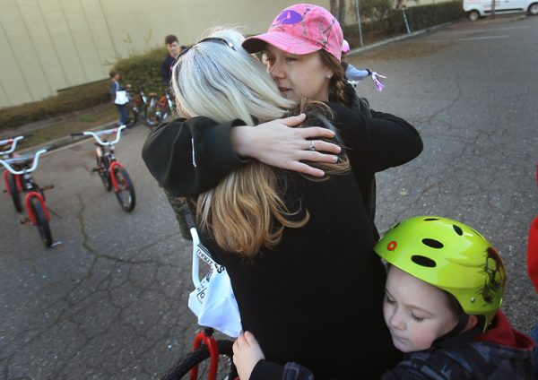 Nichole McCarty and her son Jeremiah Bishop ,6, give a heartfelt and tearful embrace to Bishop's Thomas Page Elementary school teacher Teresa Peterson, after McCarty's children were put on a list to receive new bikes from Innovative Screen Printing and Embroidery in Rohnert Park, Friday Dec. 16, 2016. (Kent Porter / The Press Democrat) 2016