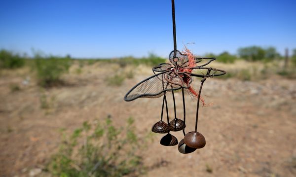 Wind chimes on an old ranch fence post where dozens of homes once stood, Friday May 19, 2017 in Saragosa. (©Kent Porter)